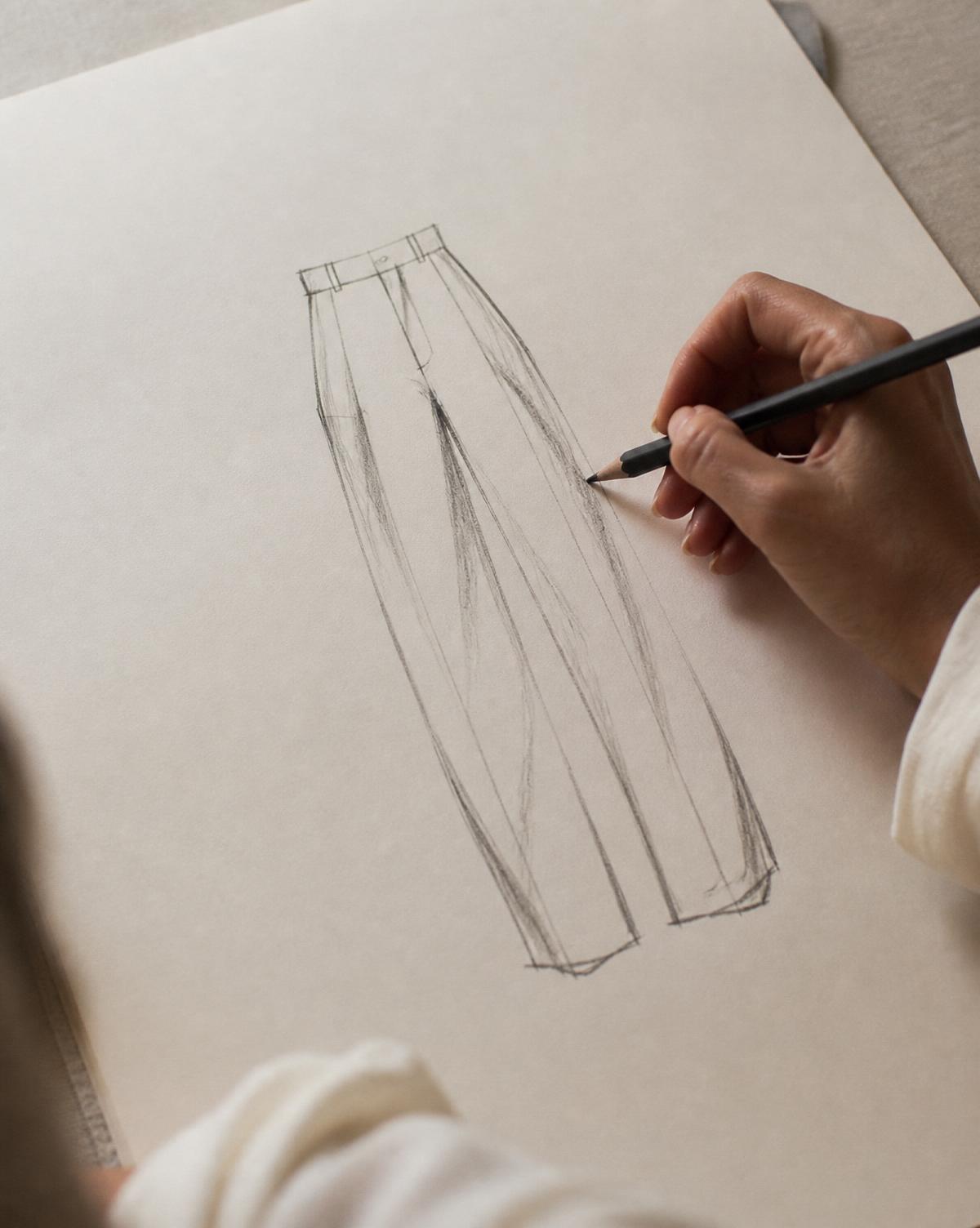 Designer sketching a trouser silhouette in graphite