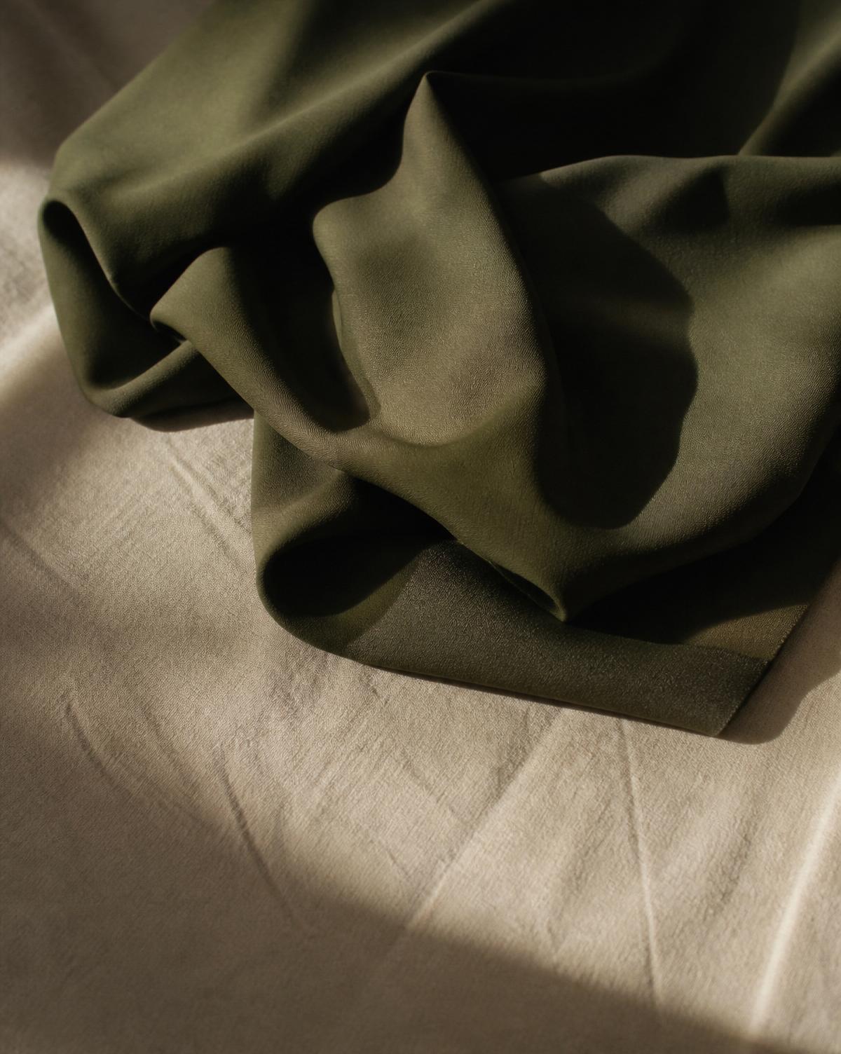 Draped olive wool crepe on cream linen